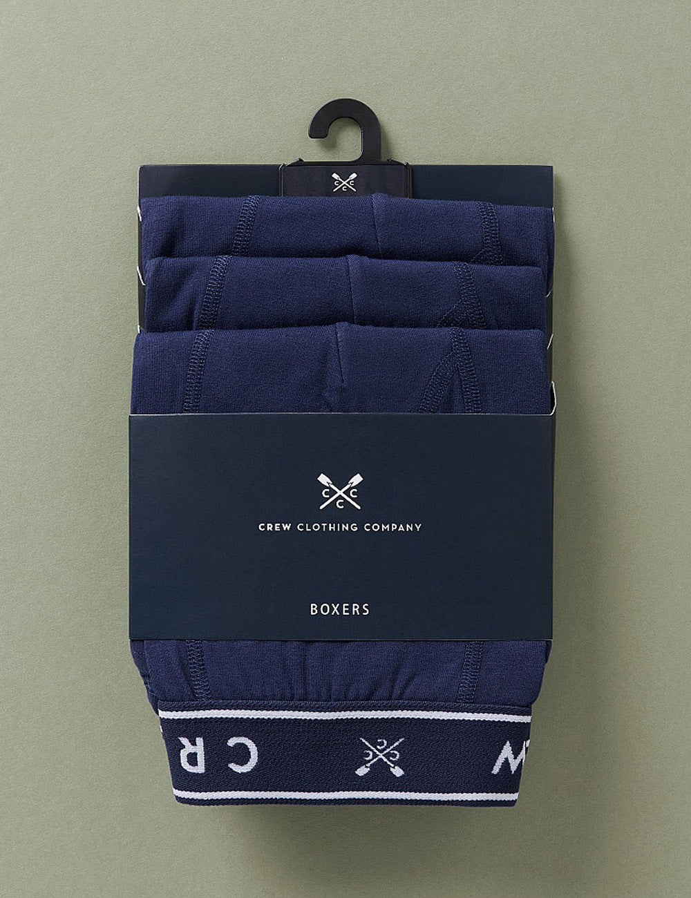 Crew Clothing's Jersey Boxers in Navy in packaging on a green background