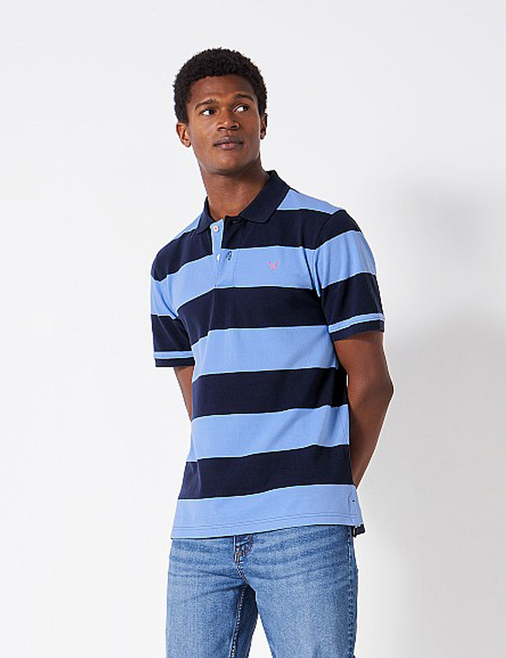 Man wearing the Heritage Stripe Polo Shirt with his hands behind him