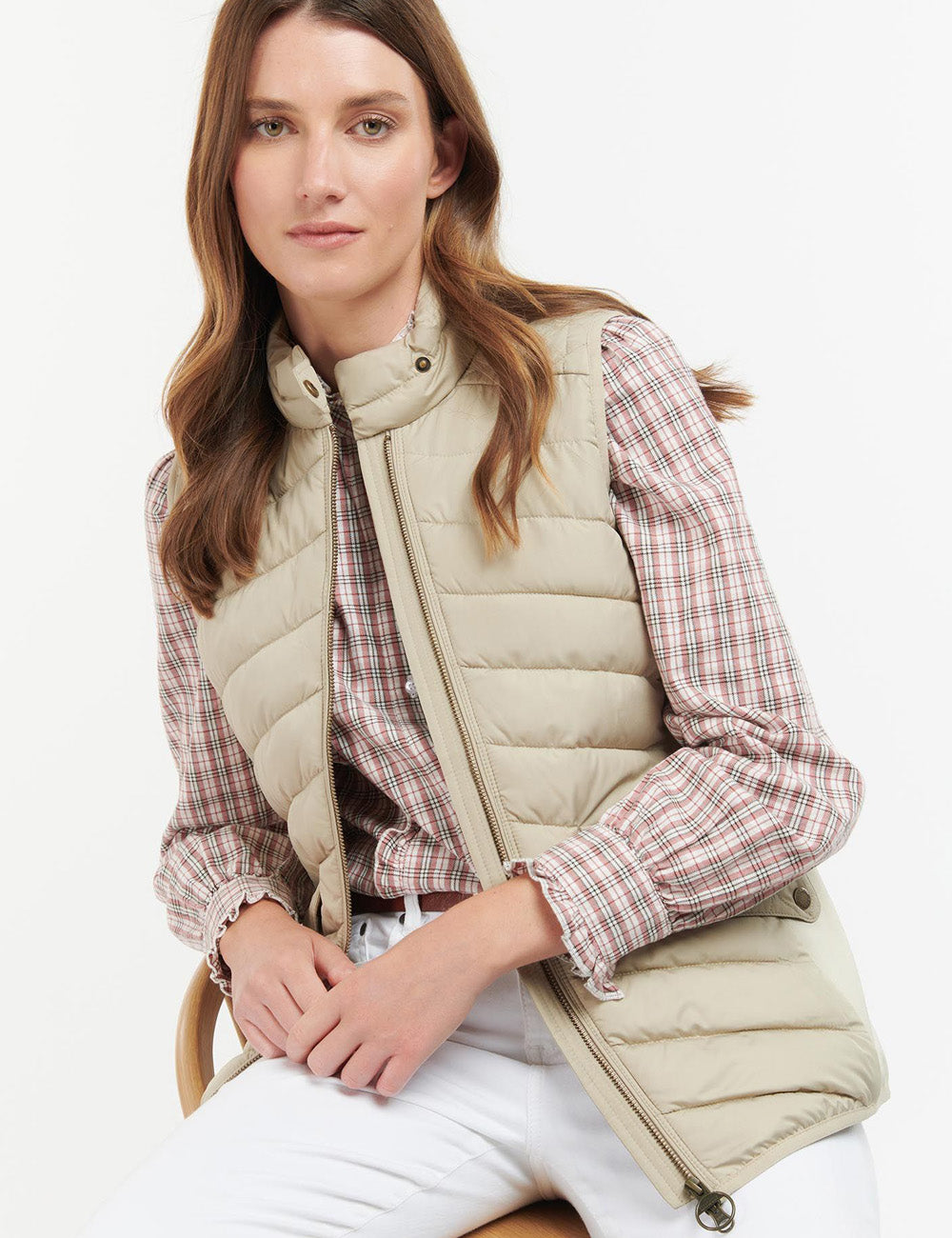 Woman sitting down wearing the Stretch cavalry Gilet from Barbour