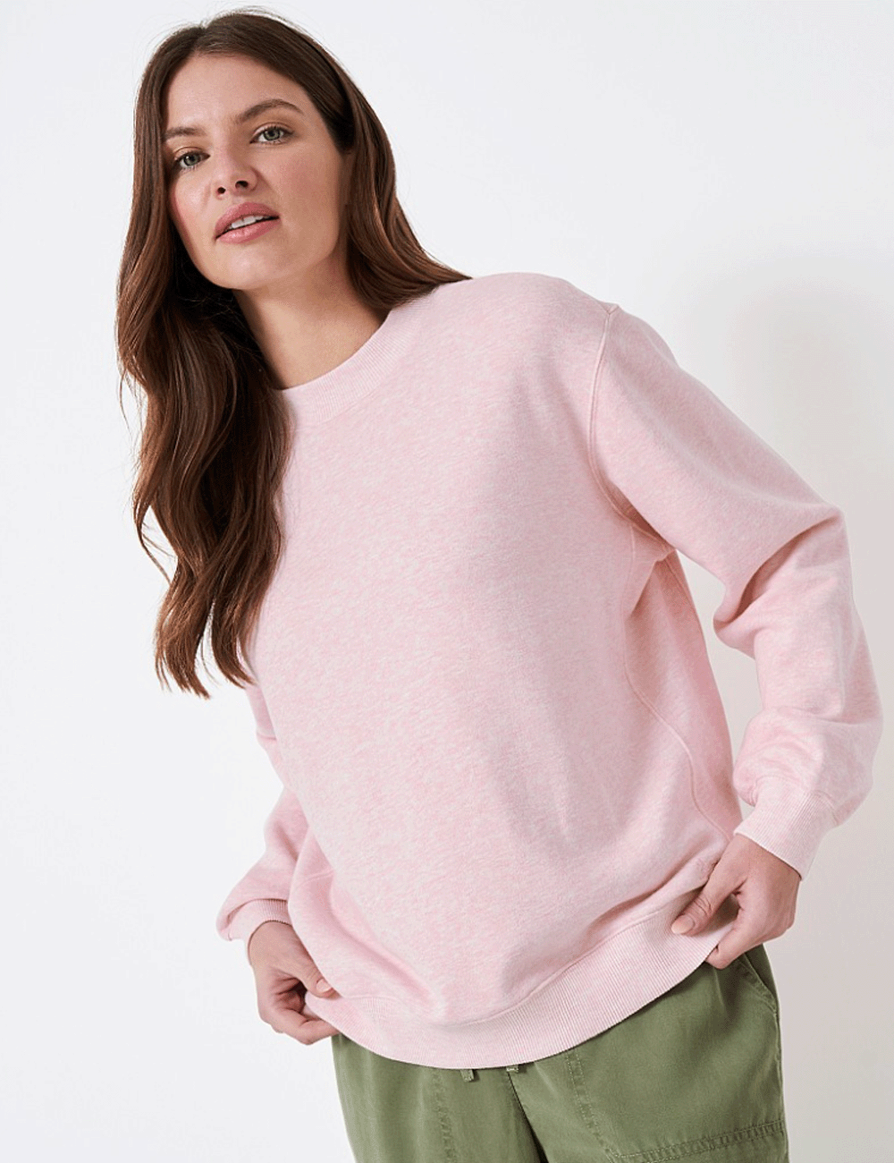 Woman wearing the Essential Oversized Sweatshirt holding the hem with both hands