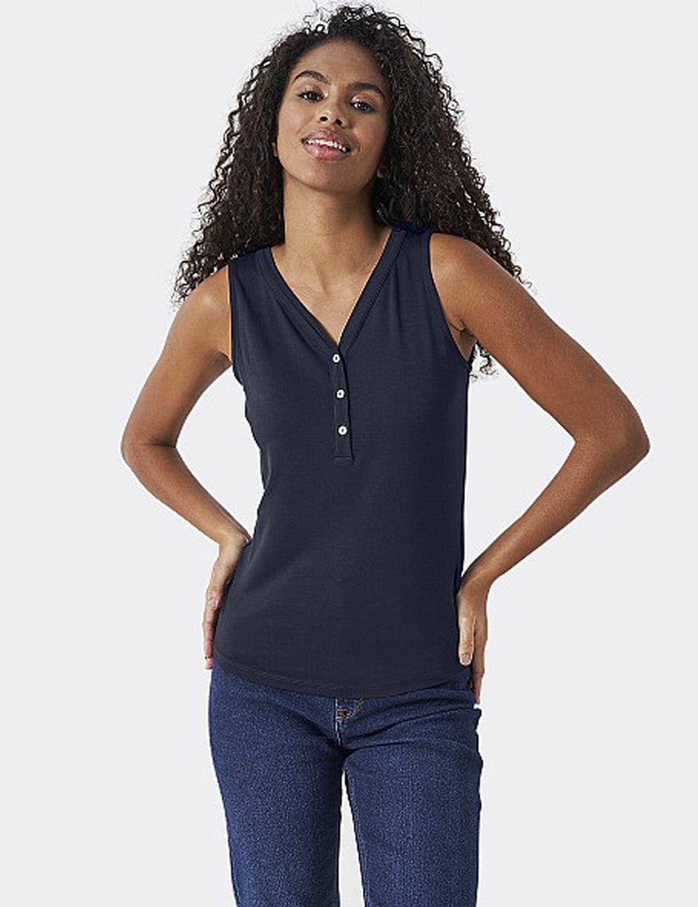 Woman wearing the Henley Vest with jeans, her hands on her hips