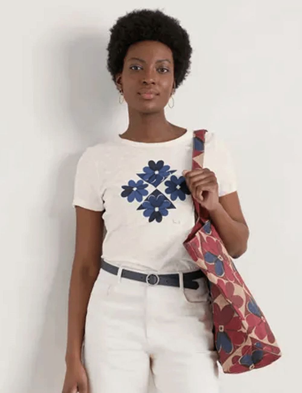 Woman wearing the Printing Ink T-Shirt with white jeans holding a bag over her shoulder