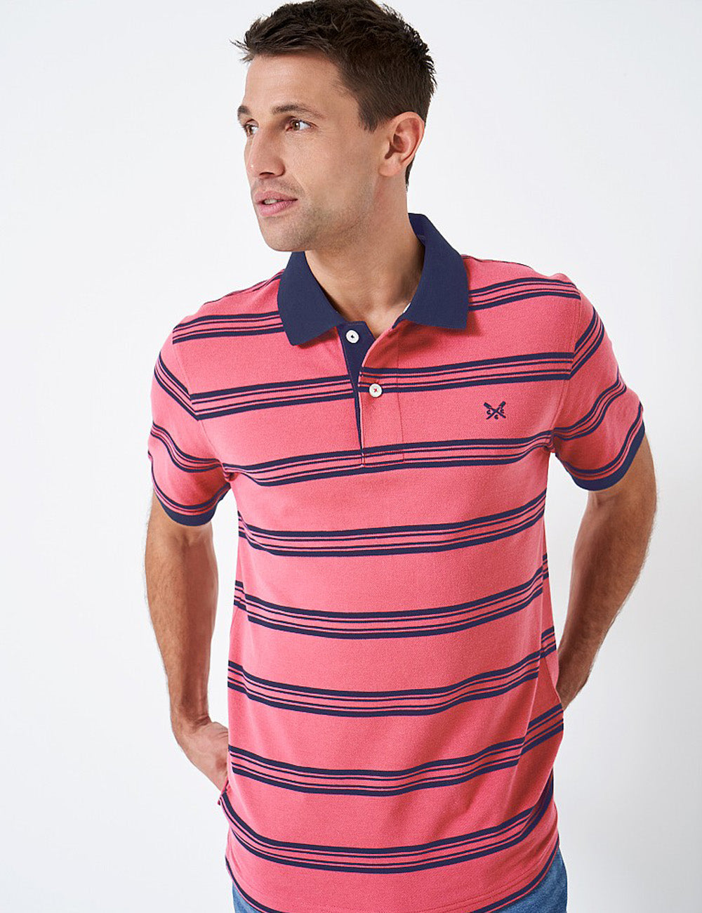 Man wearing the Westcott Polo with jeans, holding the back hem with his hands