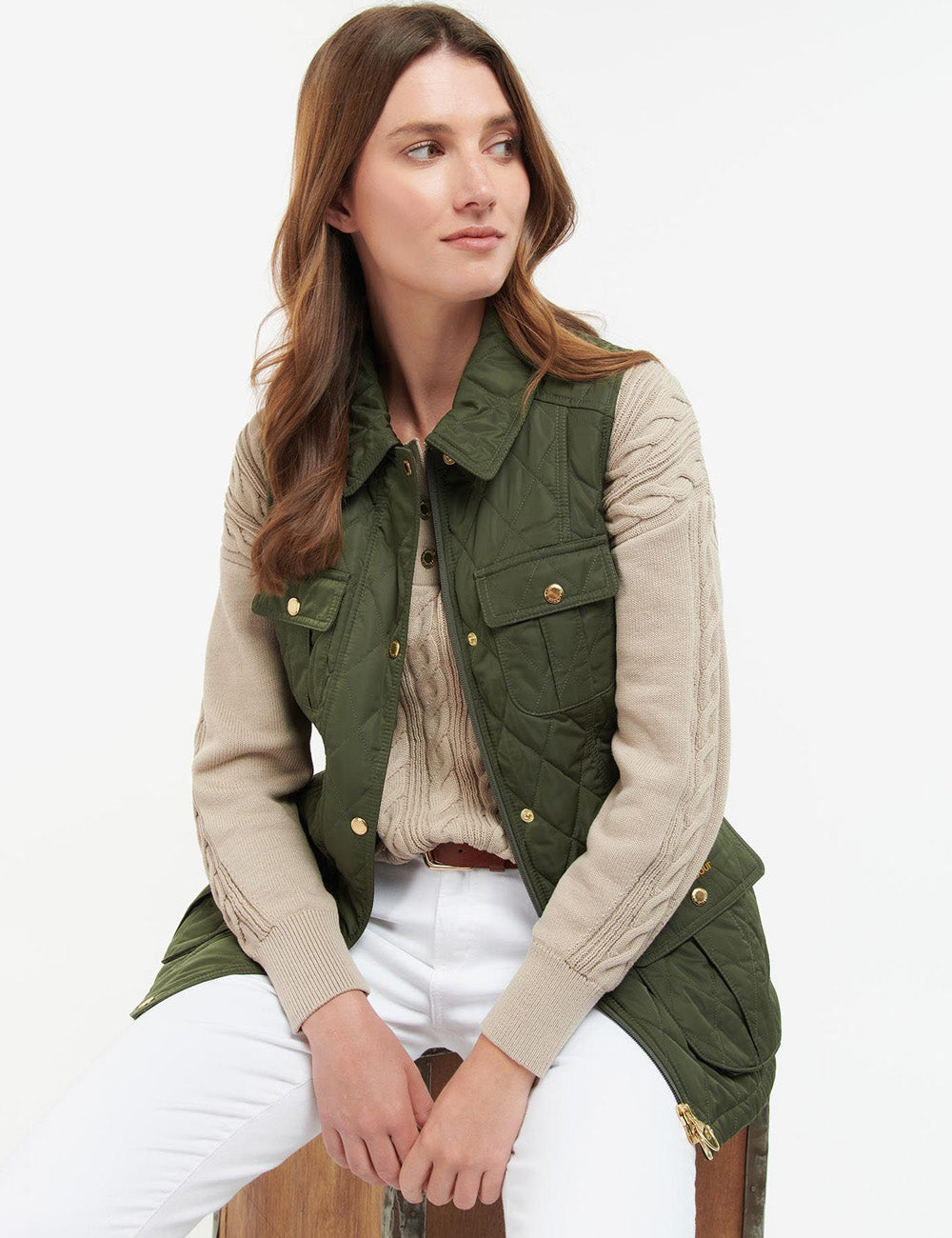 Woman sitting down wearing the Barbour Belted Defence Gilet